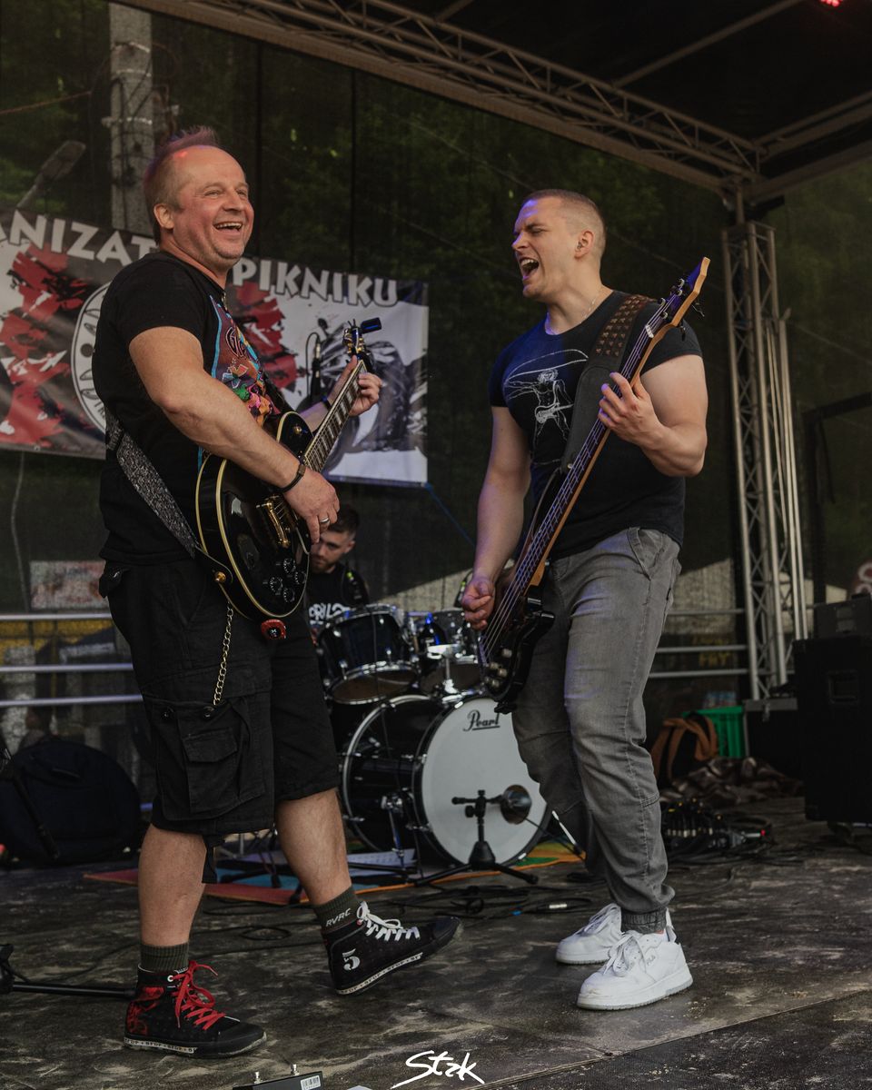 Dwaj gitarzyści zespołu Biała Wilczyca grający podczas koncertu