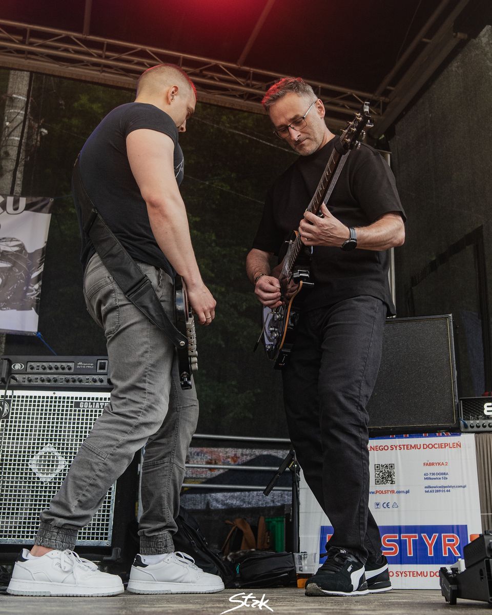 Gitarzyści zespołu Biała Wilczyca w akcji na scenie, ujęcie z dołu
